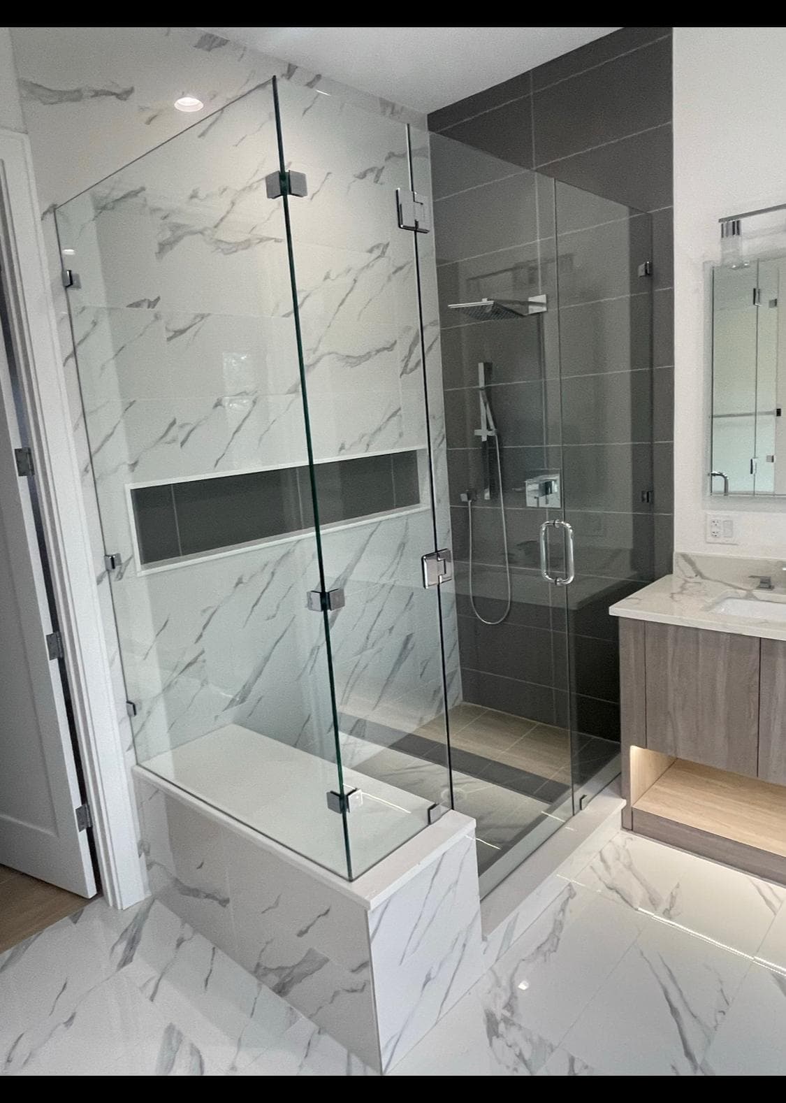 Marble-clad shower with full glass enclosure and polished nickel fixtures — master bathroom remodel