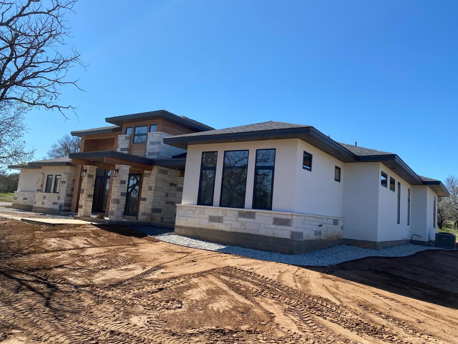 Prairie-modern custom home with stone and cedar — new construction by Epic Homes, Bee Cave TX